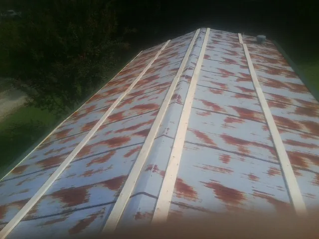Rusted metal roof panels with new wood purlins before replacement — Storm Damage Roof Repair in Schoolcraft by Roofing Brothers
