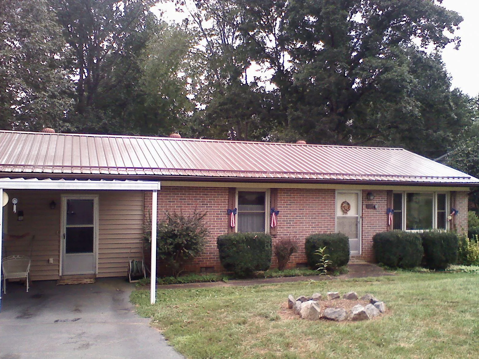 Bronze metal roof and carport on a brick ranch home — Roof Repair work by our crew in Schoolcraft